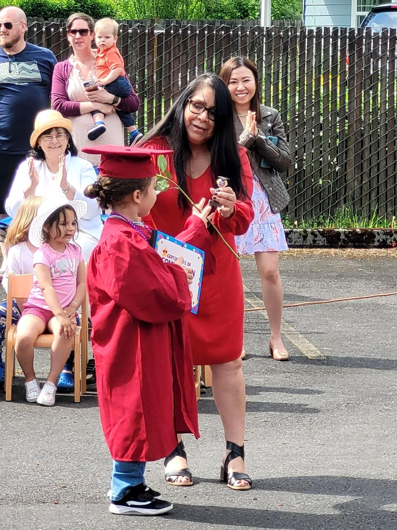 Preschool graduate receiving diploma