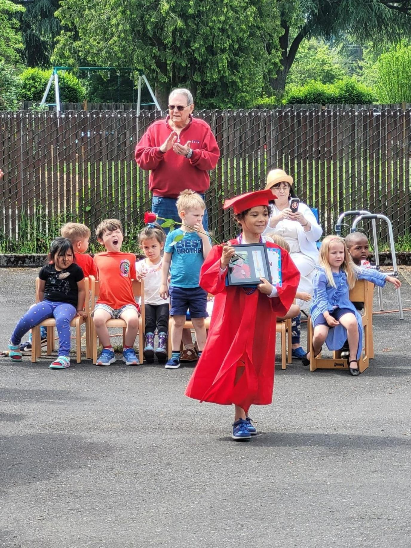 Preschool graduate holding diploma