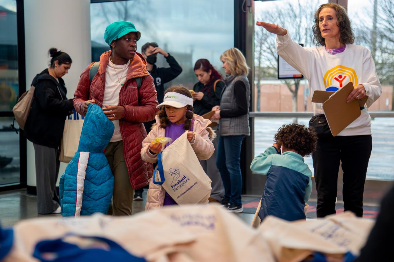United Way staffer/volunteer directing family at OMSI