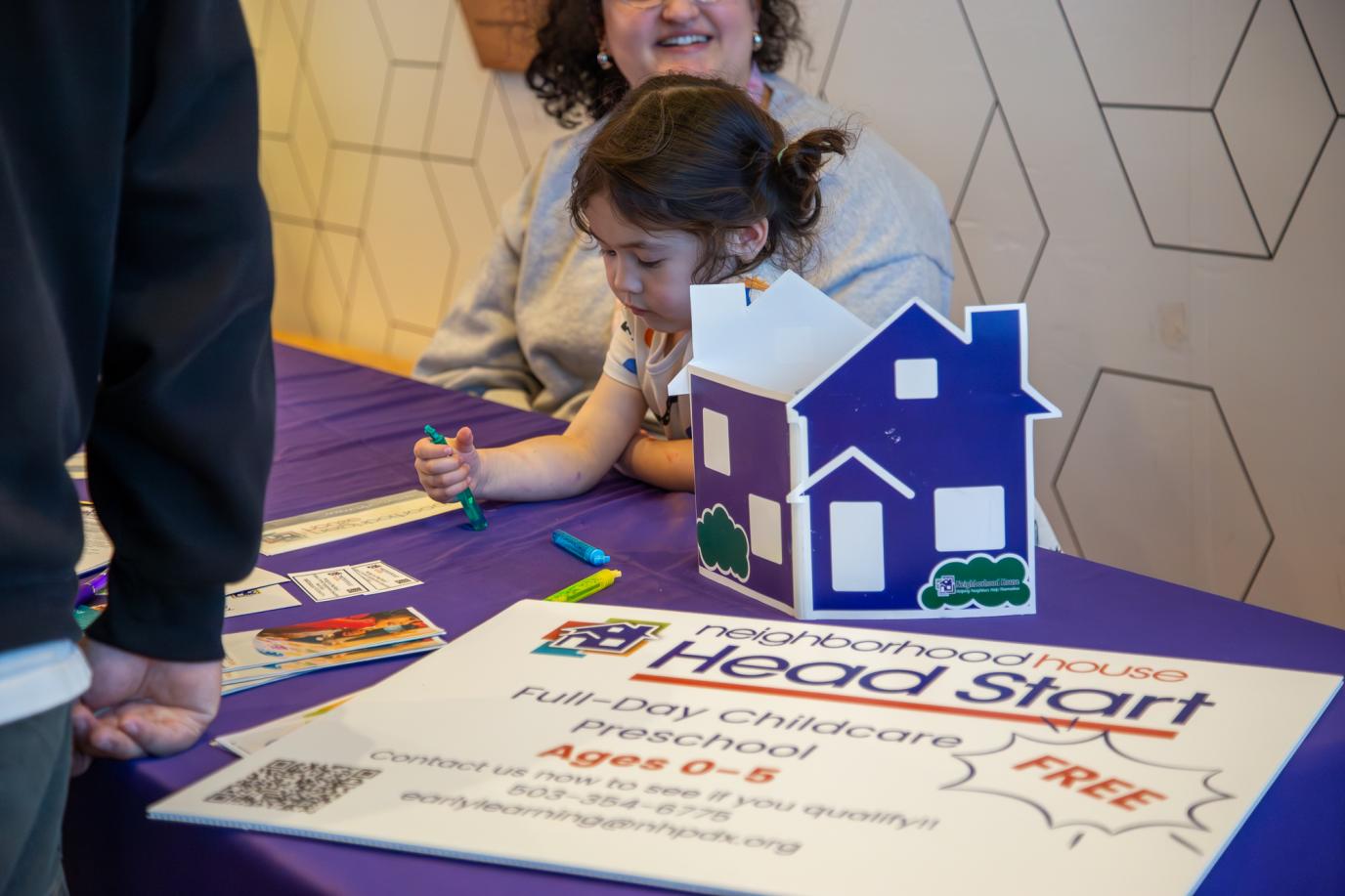 Child at  Neighborhood House booth at OMSI