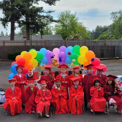 group photo of preschoolers in red graduation gowns